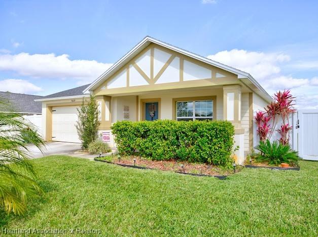 view of front of property featuring a garage, driveway, and a front lawn