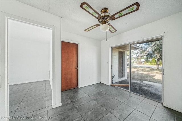 tiled empty room featuring a textured ceiling and ceiling fan