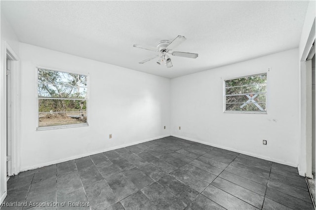 empty room with a textured ceiling and ceiling fan