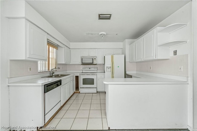 kitchen featuring white cabinetry, sink, kitchen peninsula, white appliances, and light tile patterned floors