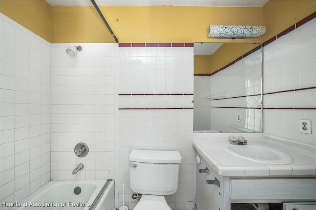 full bathroom featuring vanity, toilet, tile walls, and tiled shower / bath combo