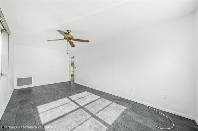 tiled spare room featuring ceiling fan