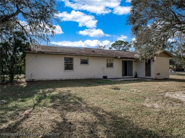 rear view of property with a yard and a patio area