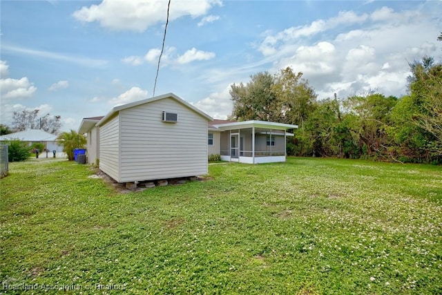 rear view of property featuring a lawn and a sunroom