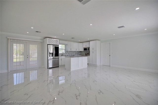 kitchen with a center island, french doors, ornamental molding, appliances with stainless steel finishes, and white cabinetry