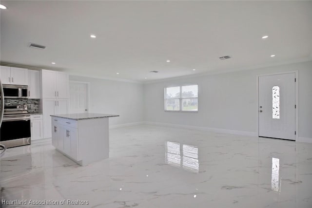 kitchen featuring decorative backsplash, appliances with stainless steel finishes, light stone countertops, crown molding, and white cabinets