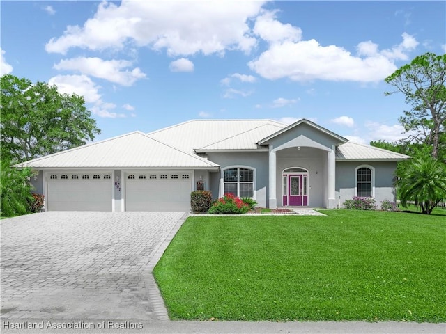 897 Entrance Rd, Avon Park, FL 33825 - view of front of house featuring a front lawn, stucco siding, decorative driveway, and an attached garage