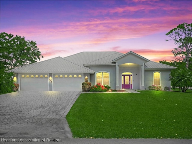897 Entrance Rd, Avon Park, FL 33825 - view of front of home with a garage, stucco siding, decorative driveway, and a lawn