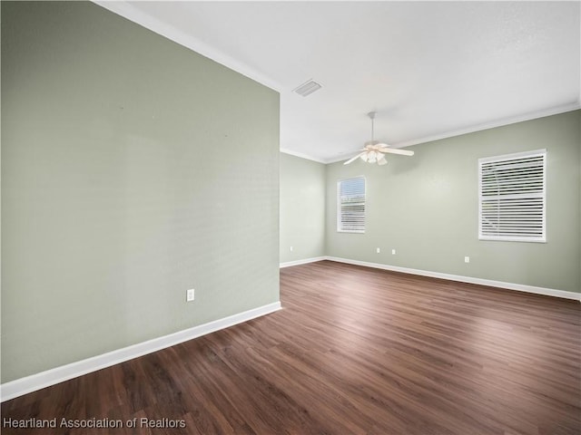 897 Entrance Rd, Avon Park, FL 33825 - unfurnished room with visible vents, baseboards, ornamental molding, ceiling fan, and dark wood-type flooring