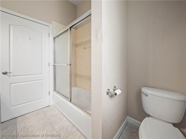 897 Entrance Rd, Avon Park, FL 33825 - bathroom featuring toilet, tile patterned floors, enclosed tub / shower combo, and baseboards