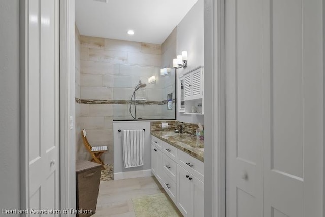 bathroom with vanity, a shower, tile walls, and radiator