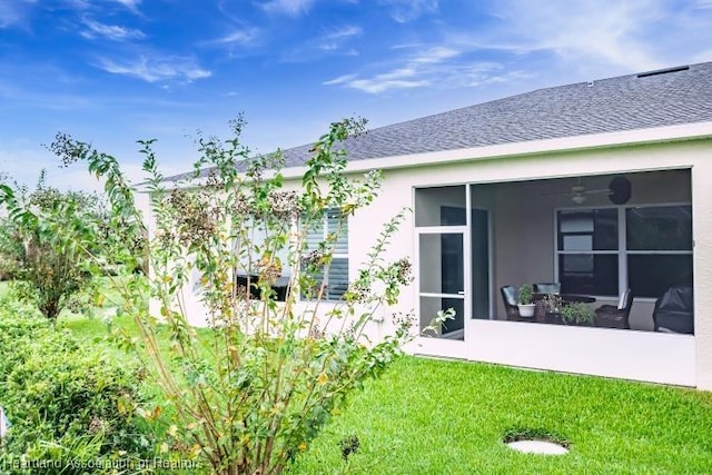 back of property with a lawn and a sunroom