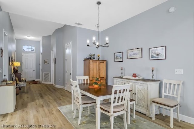 dining area featuring an inviting chandelier and light hardwood / wood-style floors