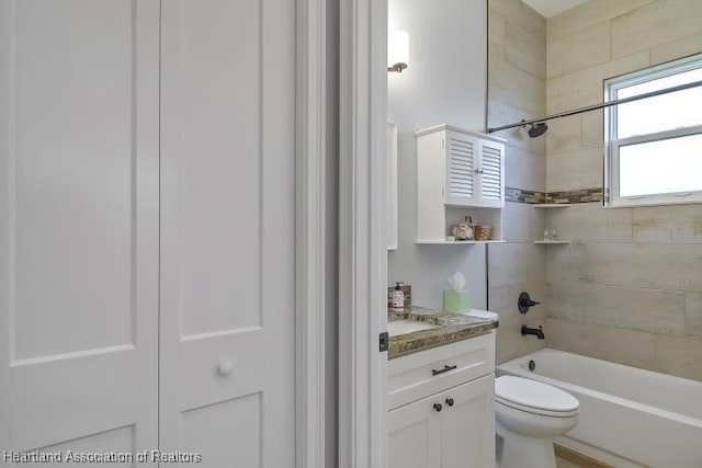 full bathroom with vanity, toilet, and tiled shower / bath