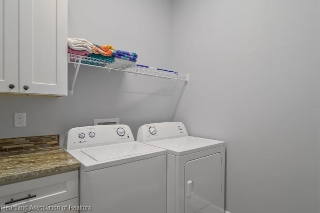 clothes washing area with cabinets and independent washer and dryer