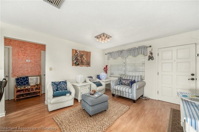 sitting room featuring hardwood / wood-style floors and a chandelier