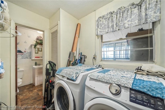 laundry area with washer and dryer and a textured ceiling