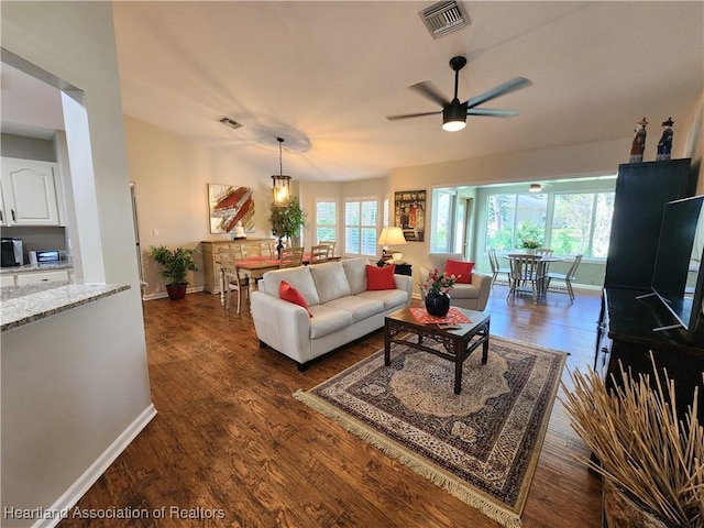 living room featuring ceiling fan and dark hardwood / wood-style flooring