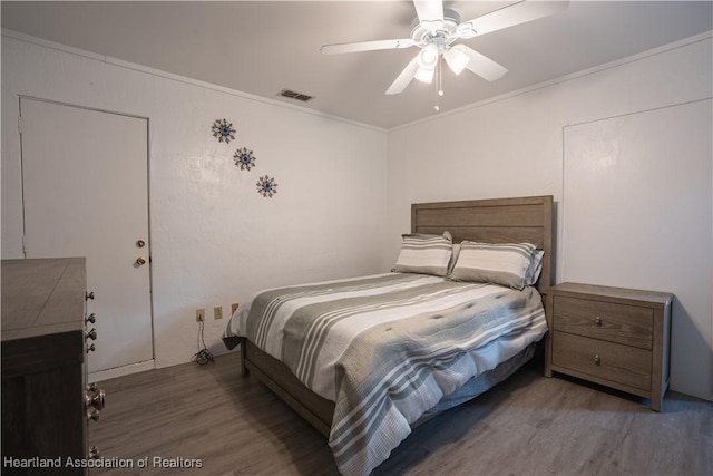 bedroom with ceiling fan, dark hardwood / wood-style flooring, and crown molding