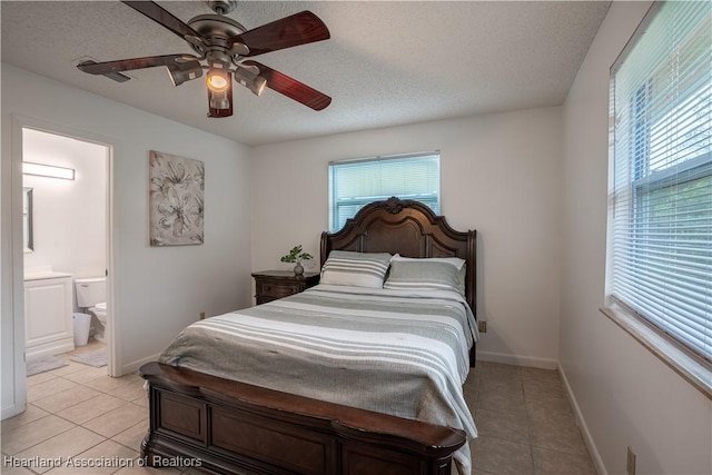 tiled bedroom featuring a textured ceiling, ceiling fan, and connected bathroom