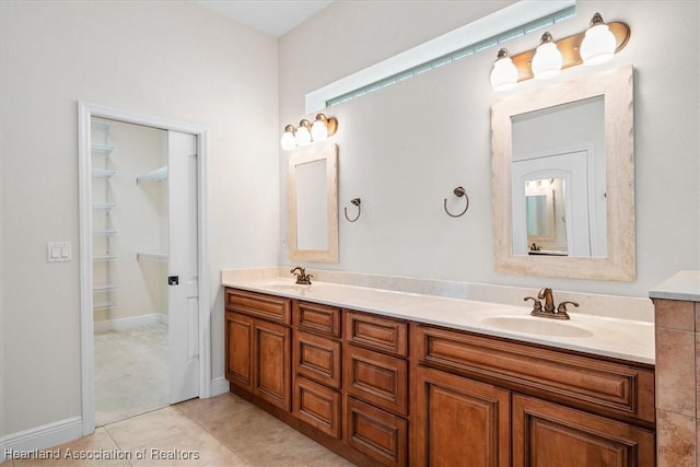 full bathroom with tile patterned floors, double vanity, a sink, and baseboards