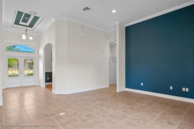 interior space with visible vents, baseboards, ornamental molding, arched walkways, and light tile patterned floors