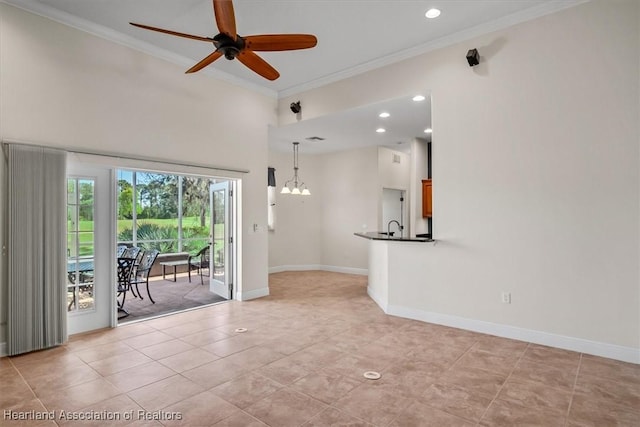 interior space featuring baseboards, crown molding, and ceiling fan with notable chandelier