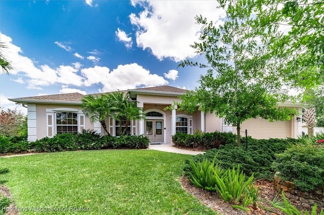 view of front of property featuring a front yard, stucco siding, a garage, and french doors