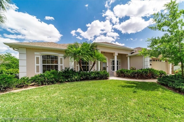 view of front facade featuring stucco siding, an attached garage, and a front lawn