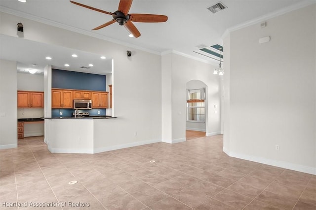 kitchen featuring crown molding, stainless steel microwave, dark countertops, visible vents, and ceiling fan