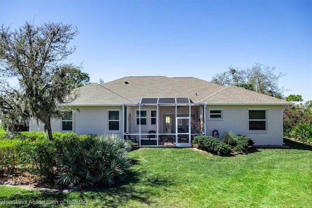 back of property featuring a lawn, roof with shingles, stucco siding, and glass enclosure