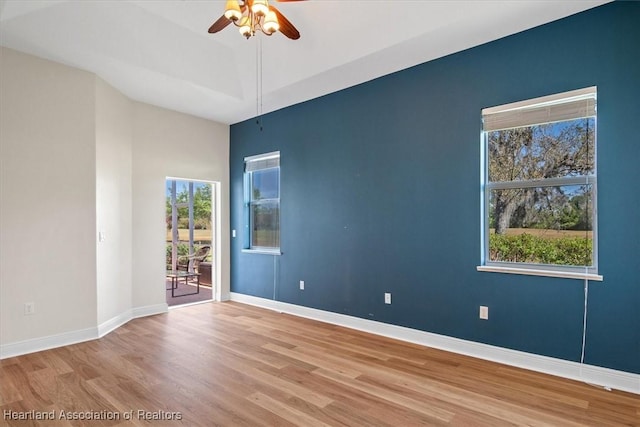 unfurnished room with baseboards, wood finished floors, and a ceiling fan