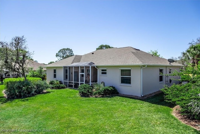 back of house with stucco siding, a shingled roof, and a yard