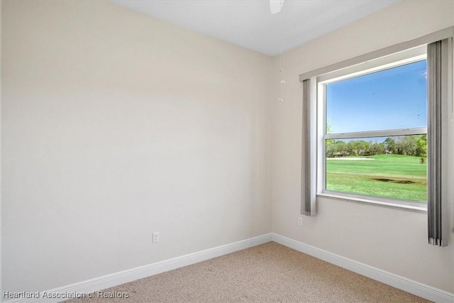 carpeted spare room featuring baseboards