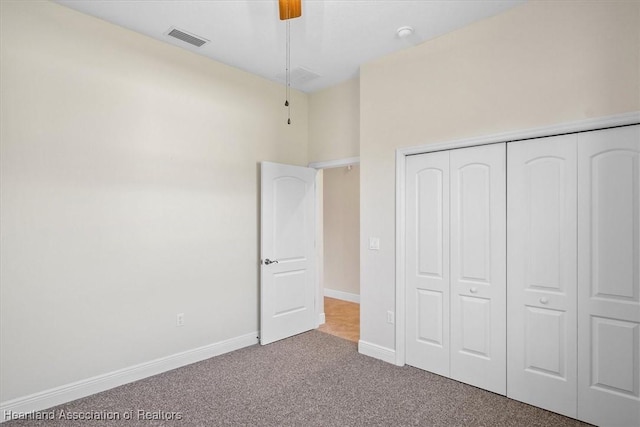 unfurnished bedroom with a closet, carpet floors, a ceiling fan, baseboards, and visible vents