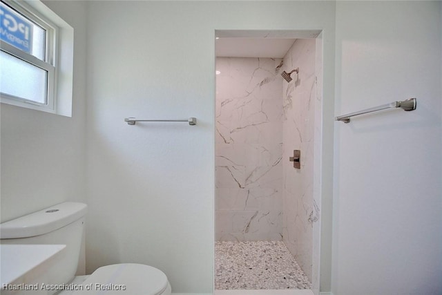 bathroom with tiled shower and toilet