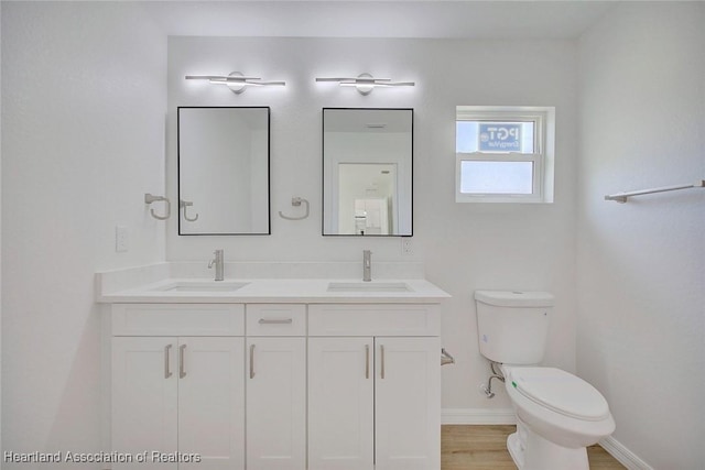 bathroom with vanity, hardwood / wood-style flooring, and toilet