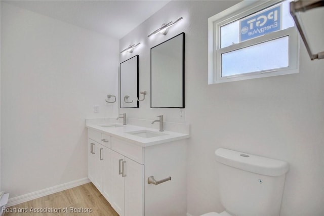 bathroom featuring hardwood / wood-style floors, vanity, and toilet