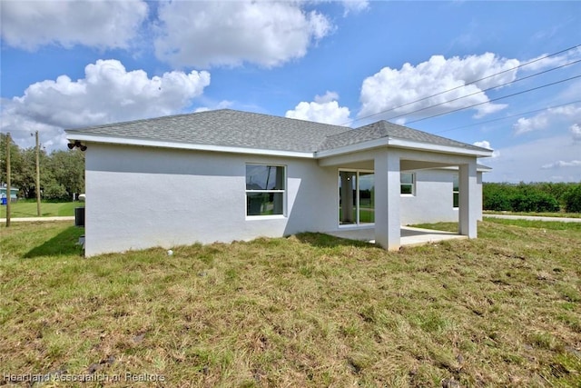 rear view of house featuring a yard and a patio area