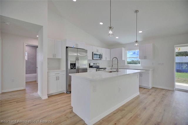 kitchen with white cabinetry, sink, hanging light fixtures, and appliances with stainless steel finishes