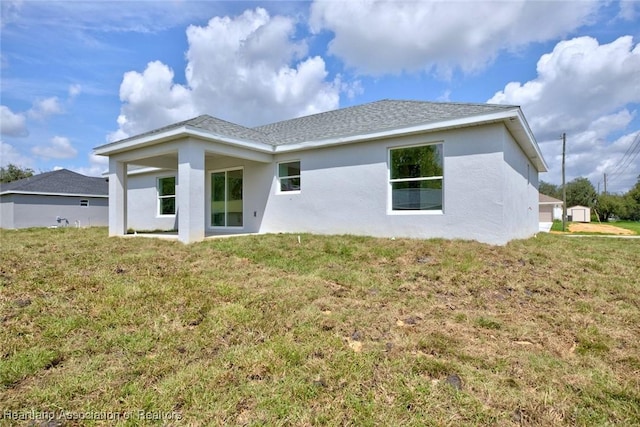 rear view of property featuring a lawn