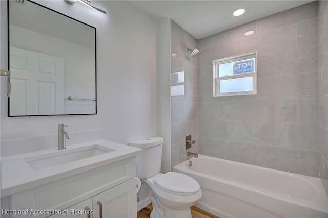 full bathroom with tiled shower / bath combo, toilet, and vanity