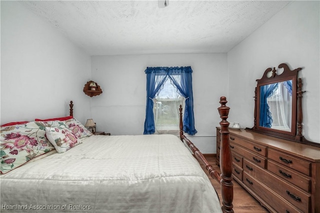 bedroom with hardwood / wood-style flooring and a textured ceiling