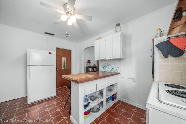 kitchen with ceiling fan, white fridge, and white cabinets