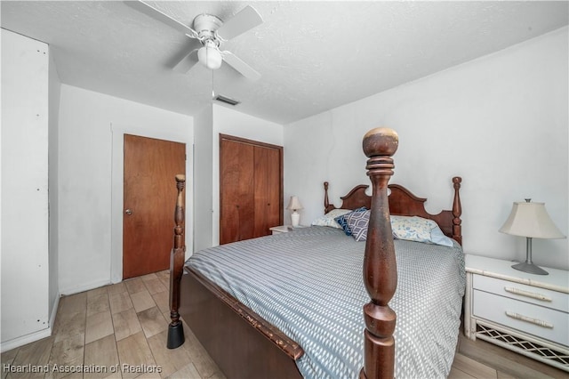 bedroom with ceiling fan, a closet, a textured ceiling, and light wood-type flooring