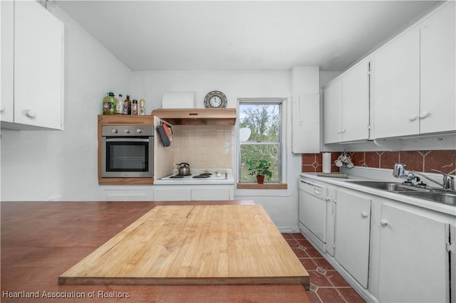 kitchen featuring white appliances, sink, decorative backsplash, and white cabinets