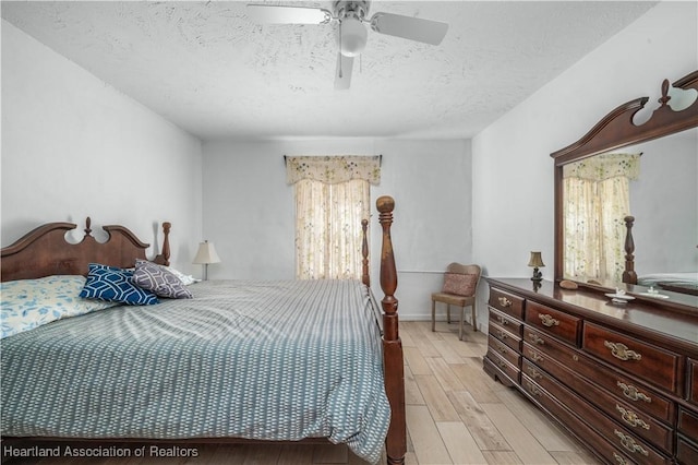 bedroom featuring ceiling fan, light hardwood / wood-style flooring, and a textured ceiling