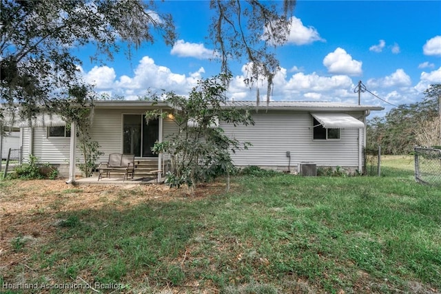 back of house featuring a patio, a yard, and central AC