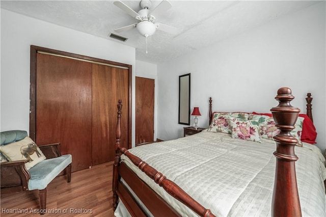 bedroom featuring hardwood / wood-style flooring, ceiling fan, a closet, and a textured ceiling