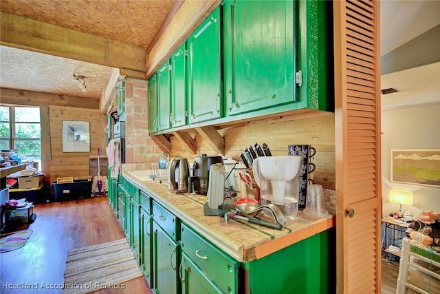 1320 Lakeview Dr, Sebring, FL 33870 - kitchen with green cabinets, wood finished floors, wooden walls, and a textured ceiling